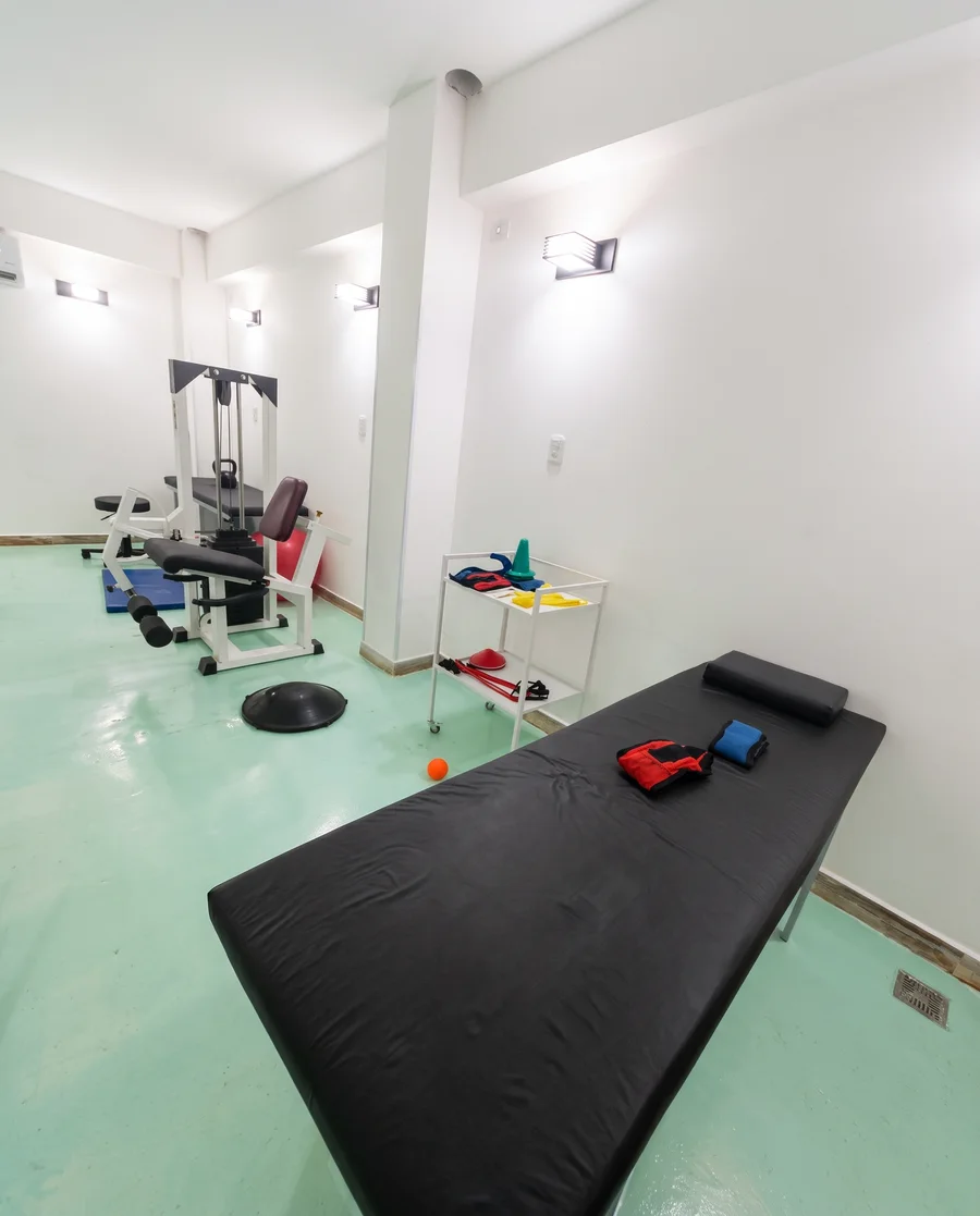 Sala con máquina de ejercicios y camilla